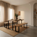Dining area with wooden table and benches in a modern interior setting.